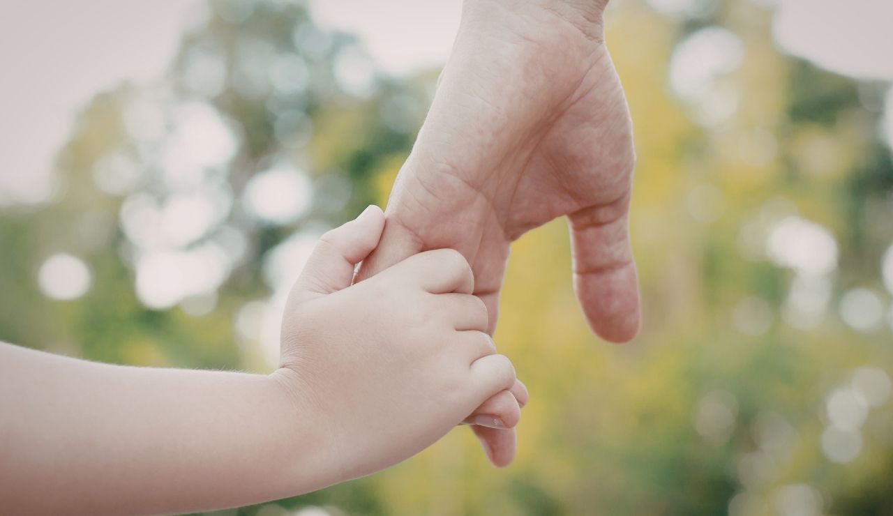 Mantenimento figli: mano di genitore tiene quella del figlio piccolo